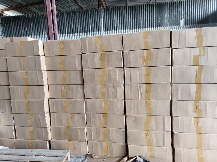 Wall of taped cartons of handle bags stacked ten high across the warehouse