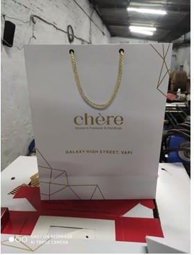 White premium bag with gold line artwork and rope handle for Chère
